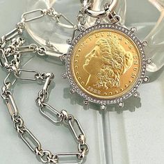 Silver Chain Necklace Beautiful reproduction vintage gold coin pendant, Morgan Peace Dollar coin in a silver bezel with cubic zirconia stones. The bale attached to the coin is also encrusted with CZ stones. The coin is 22k gold plated and elegantly hangs from a multi link Rhodium plated brass chain and a spring lock CZ clasp The spring lock closure not only makes it easy to open and close the necklace for those with difficulty but adds to the creativity of the jewelry piece. Will enhance any out Gold Coin Pendant, Silver Coin Necklace, Peace Dollar, Gold And Silver Coins, Dollar Coin, Outfit Jeans, Gold Coin, Coin Jewelry, Silver Dollar