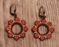 these earrings are characterized by a circular shape that recalls the shape of flowers. The main colour is orange and from here the name sunset flower Orange Beaded Flower Earrings, Rust-colored Earrings For Gift, Handmade Orange Flower Earrings, Handmade Orange Flower Shaped Earrings, Orange Flower-shaped Earrings For Gift, Handmade Red Flower Earrings, Red Round Flower Earrings With Ear Wire, Handmade Orange Flower-shaped Jewelry, Orange Circular Earrings For Gift