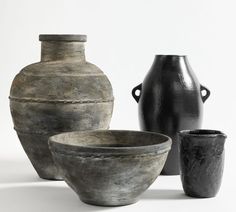 three black and white vases sitting next to each other in front of a white background