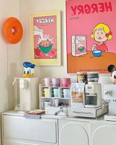 there is a coffee maker on top of the dresser in front of two posters with cartoon characters