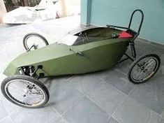 a small green car sitting on top of a cement floor