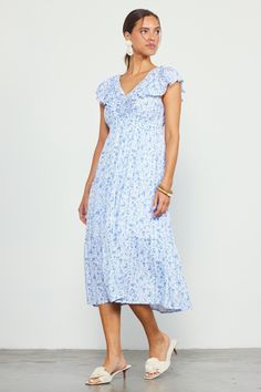 A delicate floral print and an abundance of pretty details enhance the feminine feel of this tiered midi dress. The gathered V-neckline, ruffled flutter sleeves, and dainty tie back amplify the romantic sensibility. •Gathered V-neckline •Tie detail at back •Flutter sleeves •Ruffle trim •Elasticized waist •Mid-length hem Item Number: 99798 Feminine Midi Dress With Smocked Back And Flutter Sleeves, Flowy Floral Print Midi Dress With Ruffled Straps, Flowy Floral Midi Dress With Ruffled Straps, Tiered Midi Dress With Ditsy Floral Print For Brunch, Spring Blue Tiered Dress With Ruffled Straps, Spring Blue V-neck Tiered Dress, Feminine Blue Floral Dress With Ruffles, Blue V-neck Tiered Dress For Spring, Blue Tiered Midi Dress With Floral Print