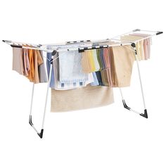 an ironing board with clothes hanging from it's sides and two racks holding folded shirts