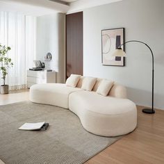 a modern living room with white furniture and wood flooring