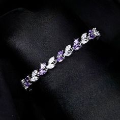 Romantic. Classy. Delicate. Rhodium plated for a flawless finish which perfectly enhances the intricate detailing, this exquisite bracelet will add a touch of sophistication to any wedding gown or formal ensemble. Each link is adorned with flawlessly faceted purple and clear cubic zirconia that capture the light from every angle with a perfectly translucent appeal, sparkling beautifully. Available in two lengths: 6.5" (approx. 16.5cm) and 7.75" (approx. 19.6cm). To make your choice select your p Silver Cubic Zirconia Charm Bangle, Silver Cubic Zirconia Bangle Charm Bracelet, Elegant Crystal Bangle With Sparkling Stones, Elegant Adjustable Crystal Bangle, Adjustable Crystal Bangle Elegant Style, Adjustable Elegant Crystal Bangle, Cubic Zirconia Sterling Silver Wedding Bracelet, Sterling Silver Cubic Zirconia Bracelet For Wedding, Cubic Zirconia Sterling Silver Bracelet For Wedding