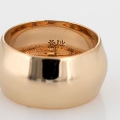 a close up of a gold ring on a white surface