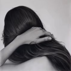 a black and white photo of a woman's head with her hands on her hair