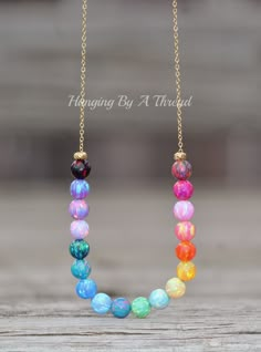 "A stunning new necklace made using opal gemstone beads and 14K gold filled. The necklace features 6mm beads in various colors. Each bead is a little work of art, and the colors are amazing! They range from red to light and dark pink, yellow, orange, blues, teals, purples, and more! Opal beads are 6mm in size, and strung onto 14K gold filled chain. Each end features a small gold plated bead. The opals are allowed to slide freely along the chain. Necklace closes with a 14K gold filled spring ring Cheap Multicolor Gemstone Bead Crystal Necklaces, Cheap Rainbow Beaded Jewelry, Cheap Rainbow Beaded Necklaces With Large Beads, Rainbow Opal, Opal Beads, Light And Dark, Opal Necklace, Dream Jewelry, Jewelry Inspo