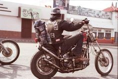 a man riding on the back of a motorcycle next to another motorcyclist