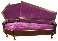 a purple couch sitting on top of a wooden table