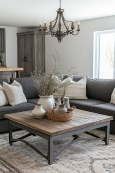 a living room filled with furniture and a chandelier hanging over the couches