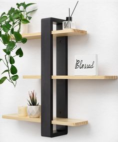 three wooden shelves with plants on them and a sign that reads blessing hanging from the wall