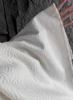 a person's hand on top of a white blanket