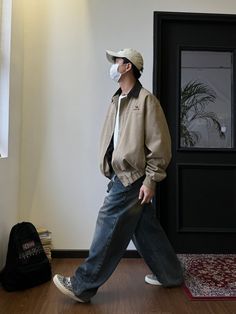 a man wearing a face mask walking in front of a door