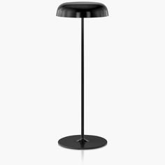 a black table lamp on a white background with the light turned on and dimming