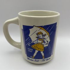 Excellent Preowned But Unused Condition This Vintage Coffee Mug From Morton Salt Features The Iconic 1956 Logo With The Famous Little Girl Holding An Umbrella. The Mug Is Made Of Durable Materials And Has A Unique White, Blue, And Yellow Color Scheme That Is Sure To Stand Out In Any Collection. The Mug Was Manufactured In China And Is A Great Piece Of Advertising Memorabilia For Fans Of The Brand. The Mug Is Perfect For Display Or For Use As A Functional Coffee Cup. It Is Ideal For Collectors Of Mugs Vintage, Vintage Mugs, Morton Salt, Yellow Colour Scheme, Bridal Party Proposal, Coffee And Tea Accessories, Coffee Kitchen, Vintage Coffee, Cute Mugs