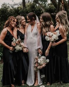 a group of women standing next to each other on top of a lush green field