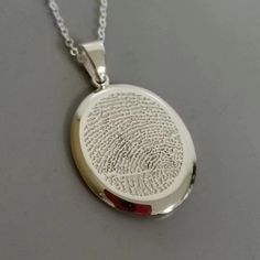 Why We Made This A beautifully emotional piece of keepsake jewelry, the Fingerprint Necklace is created using a section of your loved one's true fingerprint. The front of this lovely sterling silver oval pendant features a section of fingerprint with an engraved message of your choice on the reverse, finished with a sterling silver chain. The fingerprint is imprinted into the silver pendant with a life time no-fade guarantee. Your finished piece of jewelry will come beautifully presented in a ca Fingerprint Pendant Necklace, Thumbprint Jewelry, Thumbprint Necklace, Finger Tattoo Designs, Fingerprint Necklace, New Gold Jewellery Designs, Silver Keychain, Fingerprint Jewelry, 18k Gold Necklace