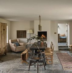 a living room filled with furniture and a fire place in the middle of an open floor plan