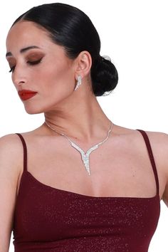 Tango performance jewelry set, White crystal rhinestone earrings, Silver sparkling wedding earrings and necklace, V shape strass necklace Isadora Tango Earrings & Necklace Set Enhance your Tango ensemble with the ideal combination of earrings and a necklace, designed to complement each other seamlessly. This jewelry set is versatile, pairing effortlessly with a wide range of outfits. Adorned with numerous rhinestones, you'll shine both on the dance floor and beyond. Pair with your favorite conDi Wedding Earrings And Necklace, Sparkling Wedding, Tango Dress, Deodorant Stains, Earrings And Necklace, Hypoallergenic Earrings, White Crystal, Drops Design, Wedding Jewelry Sets