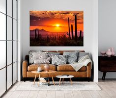 a living room with a couch, coffee table and painting on the wall above it