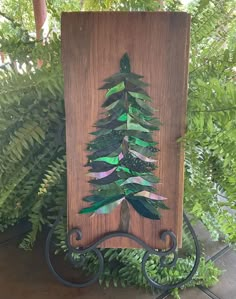 a wooden plaque with a green christmas tree on it