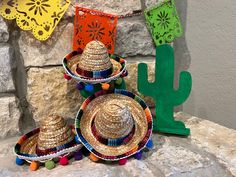 three straw hats are sitting on top of each other in front of a cactus sign