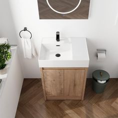 a white sink sitting under a mirror next to a green trash can on top of a wooden floor