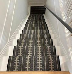 the stairs are lined with black and white carpet