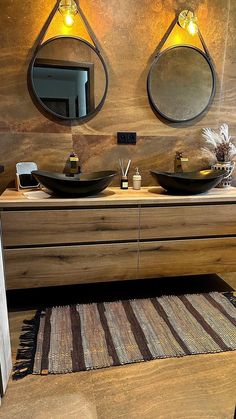 a bathroom with two sinks, mirrors and rugs on the floor in front of it