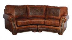 a brown leather couch sitting on top of a wooden table