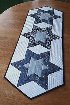 a quilted table runner sitting on top of a wooden table