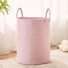 a pink basket sitting on top of a white rug