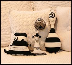 three stuffed animals sitting on top of a bed next to two pillows and a bottle