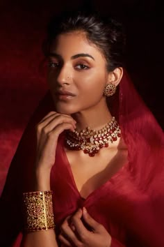 a woman in a red sari and gold jewelry