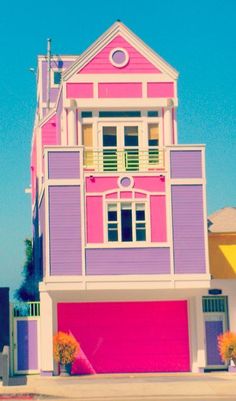 a pink and purple house on the corner of a street