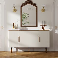 a white cabinet with a mirror on the wall and candles in vases next to it