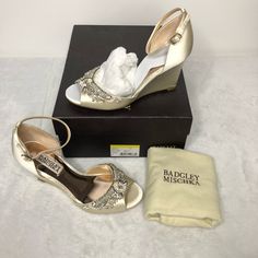 a pair of gold high heeled shoes next to a box with a handkerchief on it