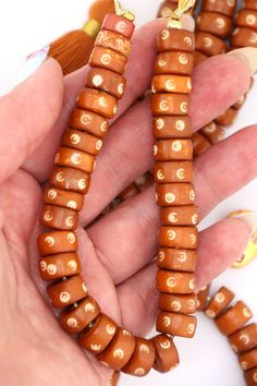 A rich, nutty shade of brown, these beads remind us of caramel and butterscotch. These earthy neutral bone beads are made in India, from water buffalo and cow bone (cruelty-free) that has been dyed in a delicious shade of brown. Circular bullseye patterns are carved into the surface of each bead. ✨The Magic is in the Details✨Approx. Bead Size: 12x6mmApprox. Hole Size: 2mmApprox. Number of beads Per Strand: 33Strand Length: 8.5"Color: Butterscotch Brown✨📿✨📿✨📿✨Curious to know about the source o Wood Beads Jewelry, Beaded Jewelry Bracelets, Cow Bones, 108 Mala Beads, African Trade Beads, Water Buffalo, Enamel Beads, Friendship Bracelets Diy, Pearl Collection