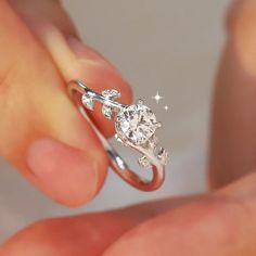 a person holding a diamond ring in their hand