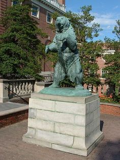 there is a statue of a bear that is standing on its hind legs in front of a building