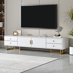 a large flat screen tv mounted to the side of a white cabinet in a living room