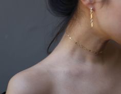 a close up of a woman's neck with gold jewelry on her left side