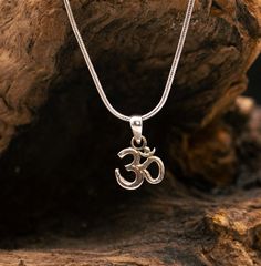 This small silver pendant shows the Om Sanskrit symbol. The divine symbol OM literally means: "I am." The OM is made up of A, U and M, which stand for the three divine aspects: Vishnu (A), Shiva (U) and Brahma (M). The vibration of the OM is considered to be the universal and eternal vibration that represents the junction between the absolute and the relative world. Everything is said to have originated from it. It has no beginning and no end. OM is not only a beautiful symbol. OM is also the sound that people have used for thousands of years to create harmony between the body, mind and soul. This is possible because ultimately all vibrations in the universe can be traced back to the primordial sound OM. The nickel-free pendant is made of 925 sterling silver and measures approx. 10 mm with Symbolic Sterling Silver Engraved Charm Necklaces, Spiritual Sterling Silver Nickel Free Charm Necklace, Nickel Free Symbolic Sterling Silver Charm Necklace, Spiritual Sterling Silver Nickel-free Charm Necklace, Spiritual Sterling Silver Hypoallergenic Necklace, Spiritual Hypoallergenic Sterling Silver Necklace, Hypoallergenic Sterling Silver Spiritual Necklace, Silver Symbolic Pendant Charm Necklace, Silver Symbolic Charm Necklace With Round Pendant