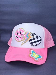 a pink and white hat with patches on it