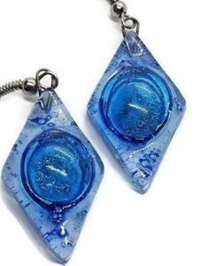 Blue glass Earrings. These earrings are handmade of recycled glass. The bubbles are unpredictable the form during the firing process and they give each bead some character and uniqueness! The glass bead is about 1.2 inches long, 0.6inches wide. The earring from the hook to the bottom of the glass is aprox 1.9 inches long Sterling silver fish hook wires. All the earrings come with rubber back stoppers. The glass is cut, painted and fired in a kiln. the bead is about one inch long and the finished Nickel-free Blue Recycled Glass Earrings, Blue Recycled Glass Nickel-free Earrings, Blue Nickel-free Recycled Glass Earrings, Blue Teardrop Recycled Glass Jewelry, Blue Recycled Glass Dangle Earrings, Blue Resin Teardrop Earrings, Blue Round Recycled Glass Jewelry, Blue Recycled Glass Round Jewelry, Dichroic Glass Jewelry