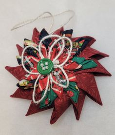 an ornament made out of red and green fabric with a button on it