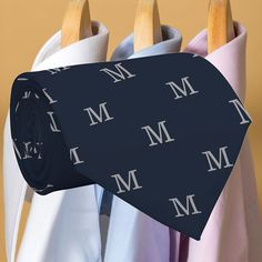 a tie with the letter m on it hanging from clothes pins