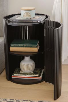 a corner table with books and a vase on it