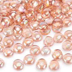 some pink glass beads are on a white surface and there is no image to describe